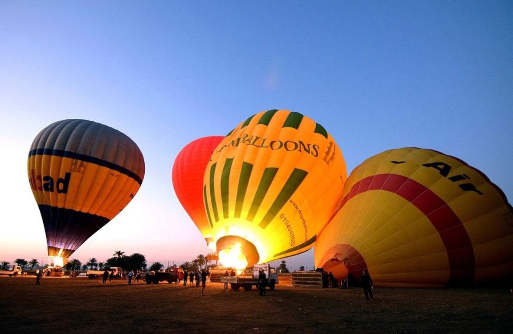 Bunte Heißluftballons starten bei Sonnenaufgang über den Tempeln von Luxor