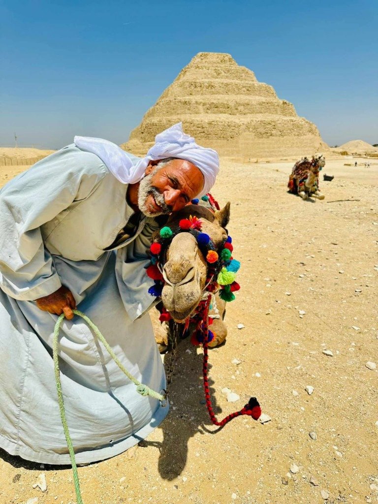 Herzliche ägyptische Gastfreundschaft: Ein einheimischer Führer mit seinem Kamel vor der Djoser-Pyramide